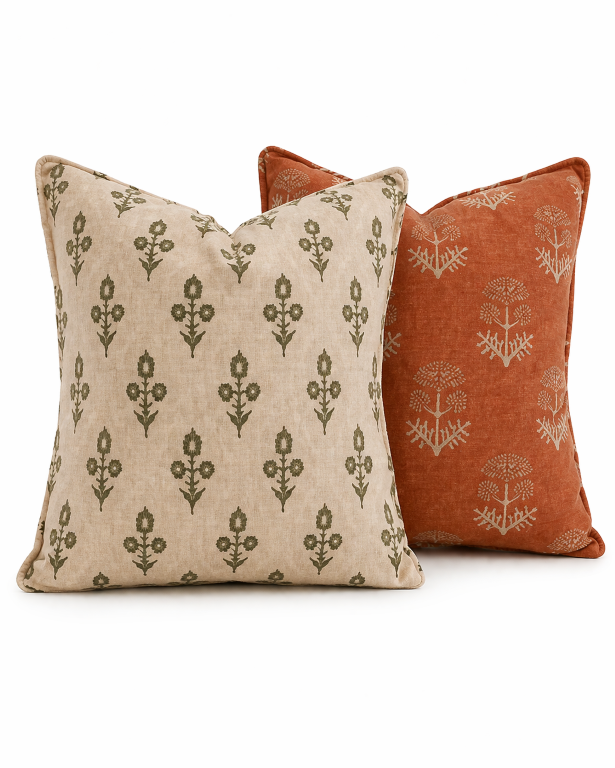 Set of 2 premium botanical cushion covers with earthy safari-inspired prints in olive green, beige, and black tones styled on a contemporary living room sofa.