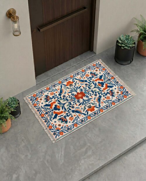 Traditional floral printed door mat in blue, orange, and ivory with intricate botanical motifs.